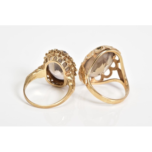 54 - TWO 9CT GOLD SMOKEY QUARTZ RINGS, the first designed with a large oval cut smokey quartz, within a s... 