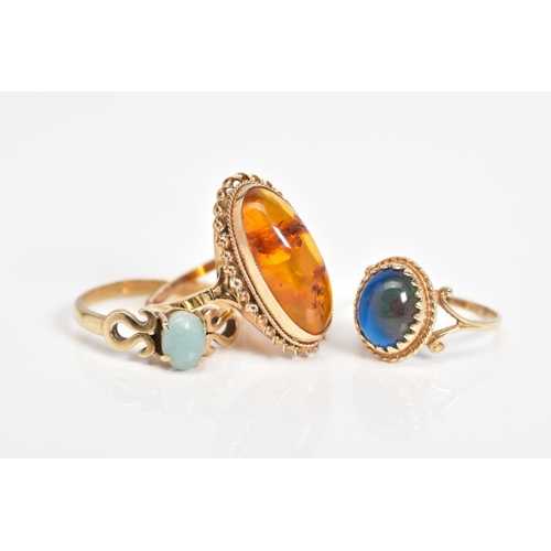 55 - THREE 9CT GOLD GEM SET RINGS, to include an oval cut amber cabochon within a rope twist surround, wi... 