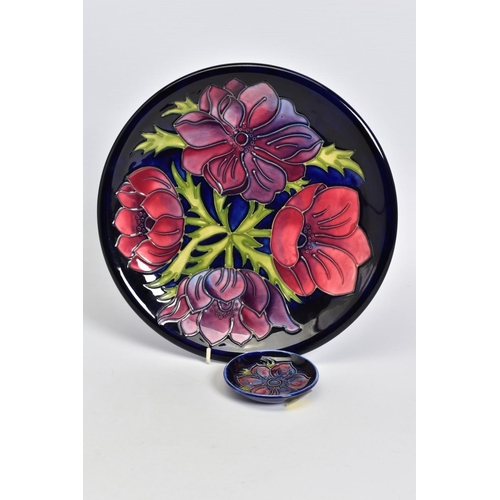 554 - A MOORCROFT POTTERY PLATE, dark blue ground with pink/purple anenomes, impressed and painted marks, ... 