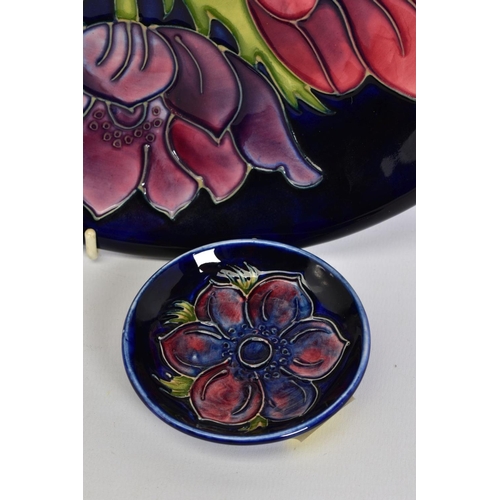 554 - A MOORCROFT POTTERY PLATE, dark blue ground with pink/purple anenomes, impressed and painted marks, ... 