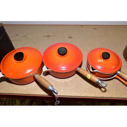 584 - THREE LE CREUSET ORANGE ENAMEL SAUCEPANS AND LIDS, two 20cm and one 16cm and a Le Creuset frying pan... 