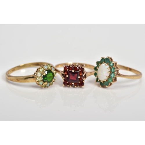 61 - THREE 9CT GOLD GEM SET CLUSTER RINGS, to include an oval cut opal with a circular cut emerald surrou... 