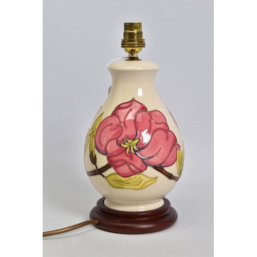 625 - A MOORCROFT POTTERY BALUSTER TABLE LAMP, cream ground with pink magnolia design, mounted on a wooden... 