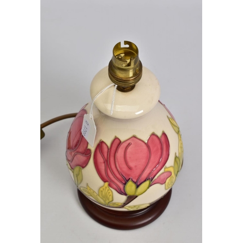 625 - A MOORCROFT POTTERY BALUSTER TABLE LAMP, cream ground with pink magnolia design, mounted on a wooden... 