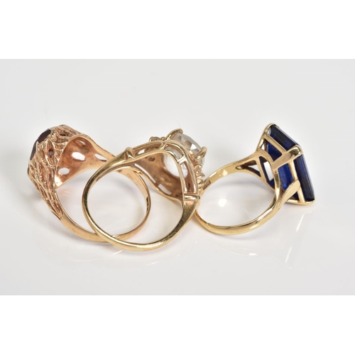 65 - THREE 9CT GOLD GEM SET RINGS, to include an oval cut topaz within a four claw setting to the circula... 