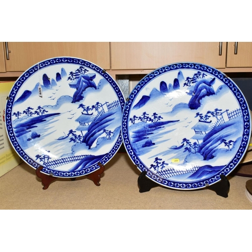 659 - A PAIR OF LATE 19TH CENTURY JAPANESE BLUE AND WHITE CHARGERS, painted with landscapes within a patte... 