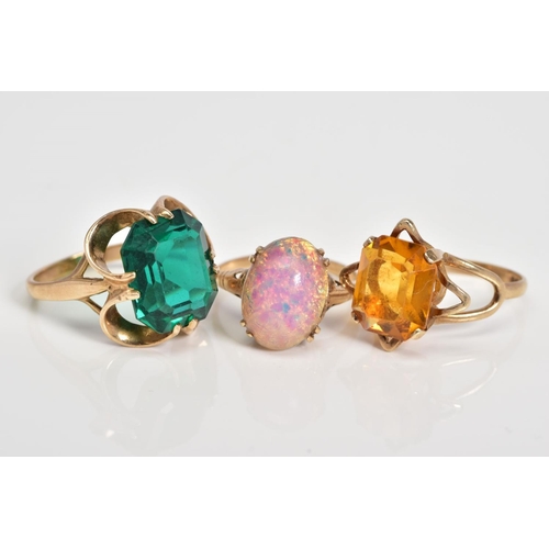 67 - THREE GEM SET RINGS, to include a cushion cut orange paste, within a four claw setting, to the bifur... 