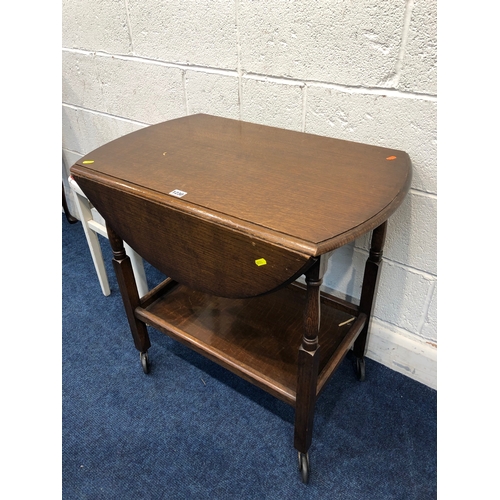 1230 - AN OAK OVAL TOP DROP LEAF TEA TROLLEY, together with a walnut circular occasional table, oak open bo... 