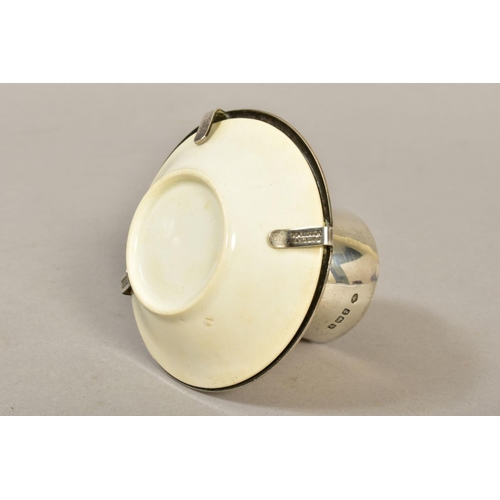 121 - A GEORGE V SILVER AND CERAMIC EGG CUP ATTRIBUTED TO A DESIGN BY CHRISTOPHER DRESSER, silver makers H... 