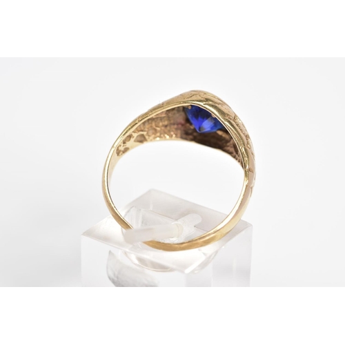 23 - A 9CT GOLD GENTLEMENS SIGNET RING, designed with a central oval cut blue stone assessed as paste wit... 