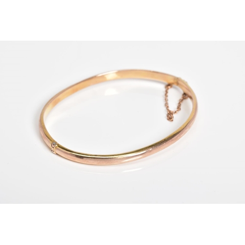 30 - A 9CT GOLD HINGED BANGLE, the plain polished hollow bangle with push pin clasp and safety chain, wit... 