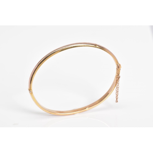 30 - A 9CT GOLD HINGED BANGLE, the plain polished hollow bangle with push pin clasp and safety chain, wit... 