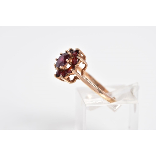 4 - A GARNET CLUSTER RING, designed with a raised cluster set with nine circular cut garnets, to the tap... 