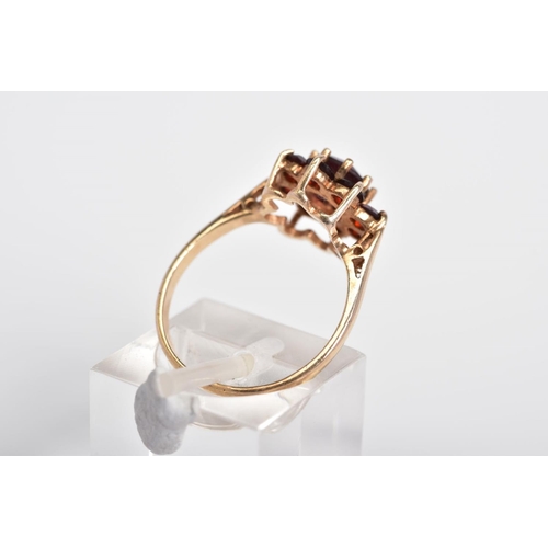 4 - A GARNET CLUSTER RING, designed with a raised cluster set with nine circular cut garnets, to the tap... 