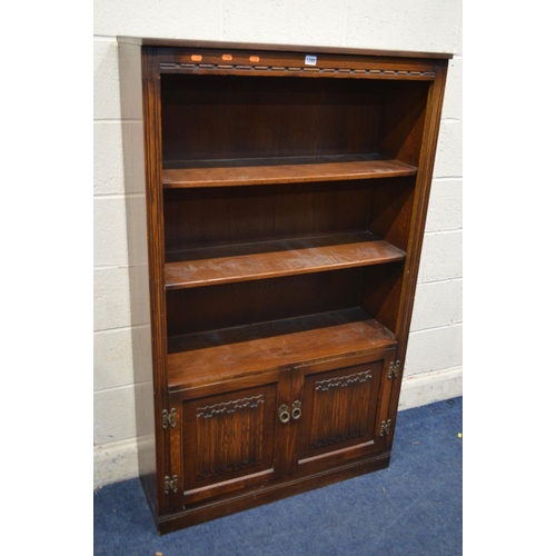 1289 - AN OLD CHARM OAK OPEN BOOKCASE, with two fixed shelves, above double linenfold cupboard doors, width... 