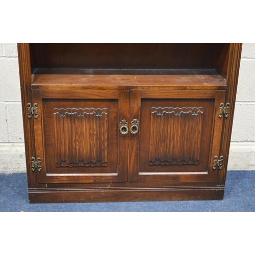 1289 - AN OLD CHARM OAK OPEN BOOKCASE, with two fixed shelves, above double linenfold cupboard doors, width... 