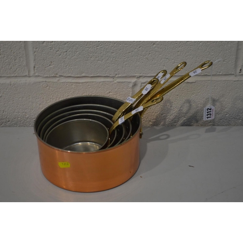 1312 - A SET OF FIVE BRASSED GRADUATED PANS, with brass hopped handles