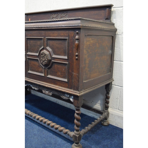 1337 - A DISTRESSED EARLY 20TH CENTURY OAK SIDEBOARD, with a raised back, double geometric panelled doors, ... 