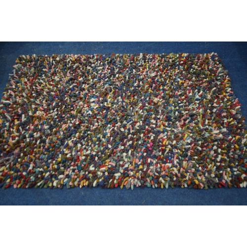 1388 - A DEEP WOOL MULTI COLOURED RUG, 192cm x 128cm (sd to one corner)