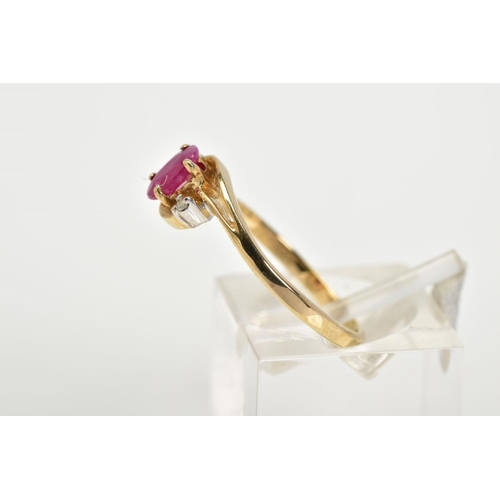 19 - A 9CT GOLD RUBY AND DIAMOND RING, the openwork crossover design, with a central claw set oval cut ru... 