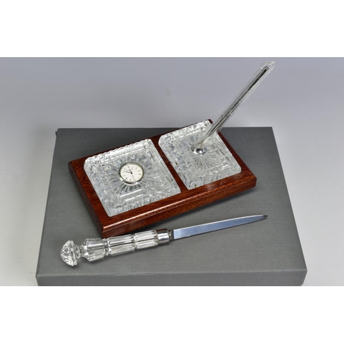 468 - A BOXED WATERFORD CRYSTAL DESK SET, comprising a quartz clock and a pen stand with pen set in a wood... 