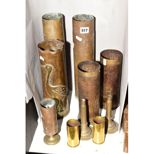 517 - A COLLECTION OF MILITARY SHELL CASES to include a case decorated with a heron and reeds, a pair of c... 