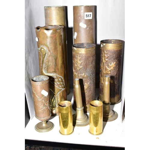 517 - A COLLECTION OF MILITARY SHELL CASES to include a case decorated with a heron and reeds, a pair of c... 