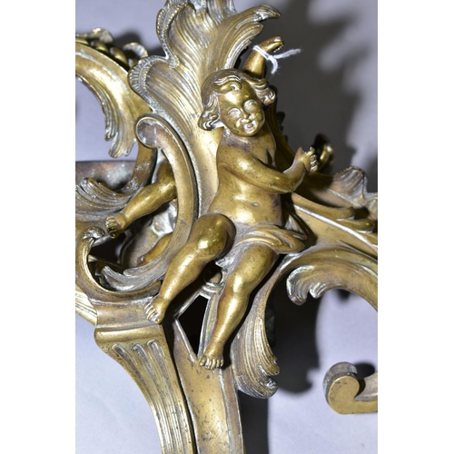 552 - A PAIR OF CAST BRASS CHERUBS ON ROCOCO SUPPORTS, possibly from a fireside fender height approximatel... 