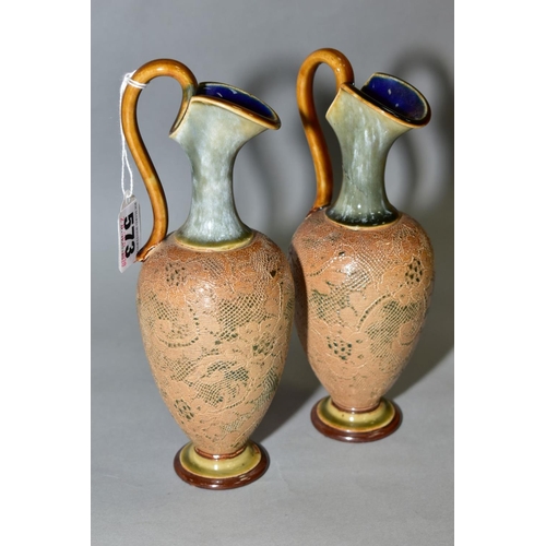 573 - A PAIR OF ROYAL DOULTON STONEWARE EWERS, blue and brown glazed handle and spout, impressed lace desi... 