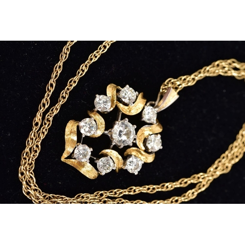 71 - A YELLOW METAL DIAMOND PENDANT NECKLACE, the yellow metal openwork scroll detail pendant set with ni... 