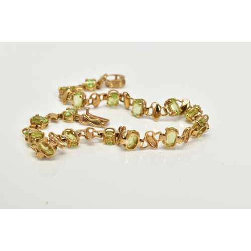 3 - A 9CT GOLD PERIDOT LINE BRACELET, set with sixteen claw set oval cut peridots each interspaced with ... 