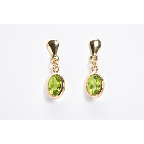 4 - A PAIR OF PERIDOT DROP EARRINGS, each designed with an oval cut peridot within a collet mount suspen... 