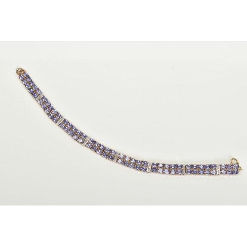 42 - AN AMETHYST AND DIAMOND BRACELET, designed with eight panels with two rows of oval cut amethyst, int... 