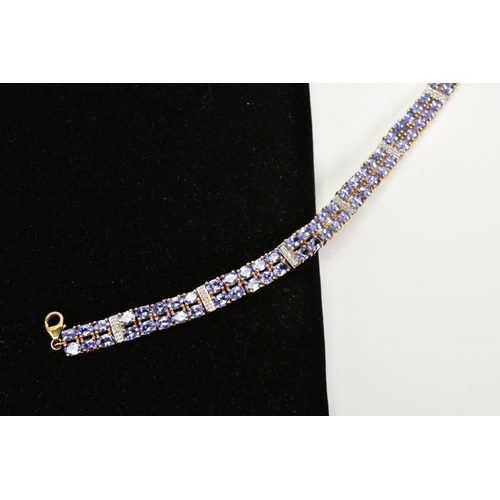 42 - AN AMETHYST AND DIAMOND BRACELET, designed with eight panels with two rows of oval cut amethyst, int... 