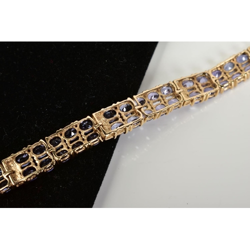 42 - AN AMETHYST AND DIAMOND BRACELET, designed with eight panels with two rows of oval cut amethyst, int... 