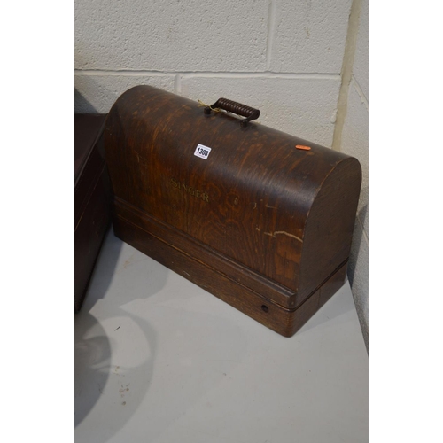 1308 - AN OAK CASED SINGER SEWING MACHINE, together with a vintage suitcase, enamel baby bath and three tab... 