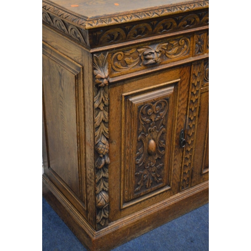 1334 - AN EARLY 20TH CENTURY CARVED OAK SIDEBOARD, foliate and lunette decoration, four drawers with lion h... 