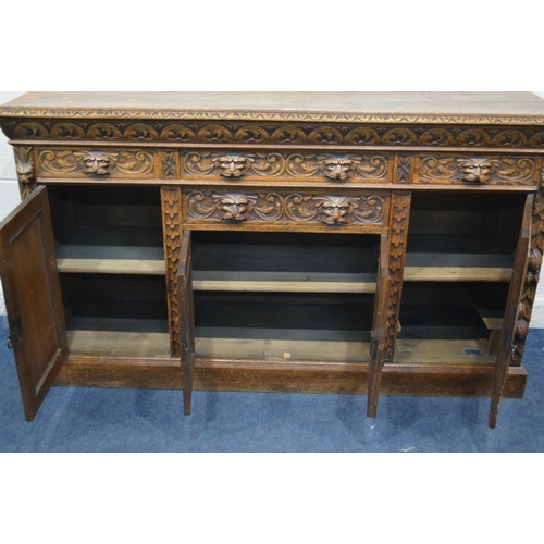 1334 - AN EARLY 20TH CENTURY CARVED OAK SIDEBOARD, foliate and lunette decoration, four drawers with lion h... 