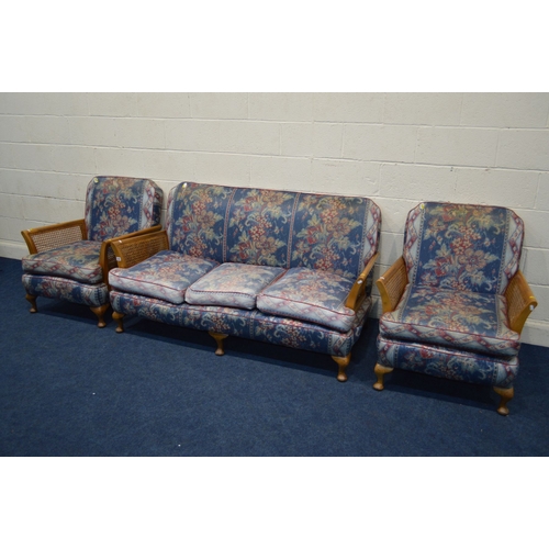 1346 - AN EARLY TO MID 20TH CENTURY MAHOGANY THREE PIECE BERGERE LOUNGE SUITE, with floral blue upholstery,... 