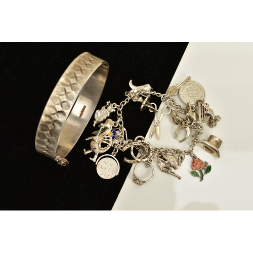 100 - A SILVER BANGLE AND CHARM BRACELET, the silver hinged bangle, with engraved detailing all round and ... 