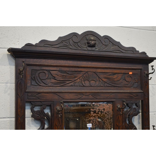 1211 - AN EARLY TO MID TWENTIETH CENTURY OAK HALL STAND, with six shaped metal hooks, distressed mirror, fl... 