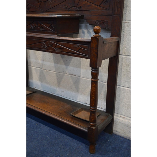 1211 - AN EARLY TO MID TWENTIETH CENTURY OAK HALL STAND, with six shaped metal hooks, distressed mirror, fl... 