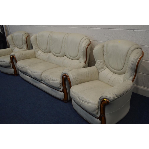 1293 - A CREAM LEATHERETTE THREE PIECE SUITE, comprising of a three seat settee and two arm chairs (3)