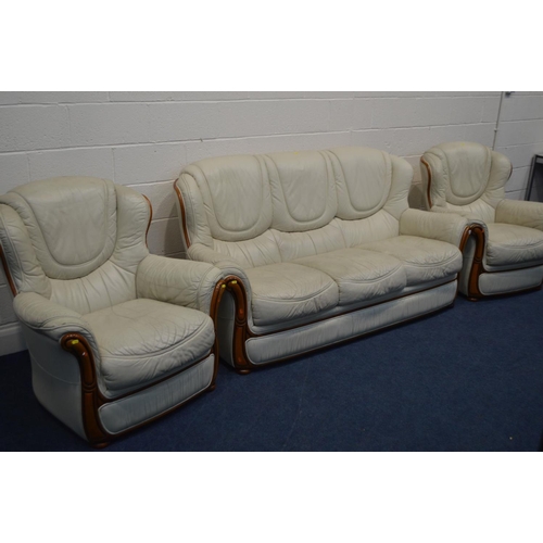 1293 - A CREAM LEATHERETTE THREE PIECE SUITE, comprising of a three seat settee and two arm chairs (3)