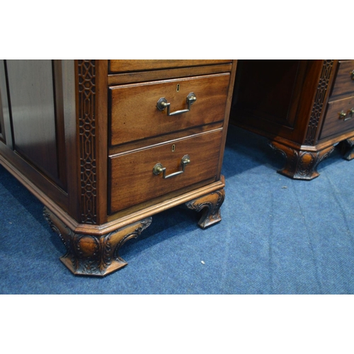 1310 - A REPRODUCTION MAHOGANY PARTNERS DESK, the top with canted corners above fretwork decoration, invert... 