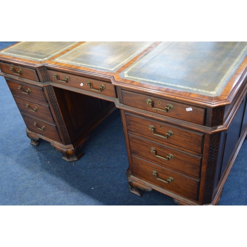 1310 - A REPRODUCTION MAHOGANY PARTNERS DESK, the top with canted corners above fretwork decoration, invert... 