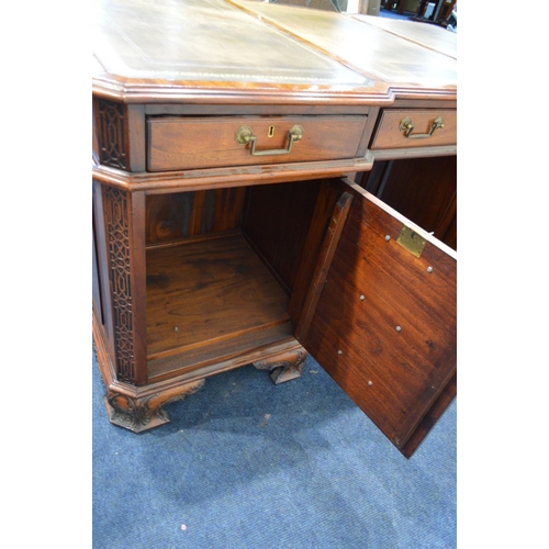 1310 - A REPRODUCTION MAHOGANY PARTNERS DESK, the top with canted corners above fretwork decoration, invert... 