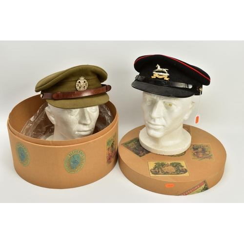 152 - A HAT BOX CONTAINING TWO MILITARY OFFICERS CAPS, a WWI era drab Olive colour peaked cap, silver colo... 