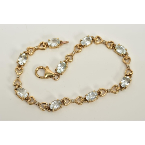 55 - A YELLOW METAL QUARTZ AND DIAMOND LINE BRACELET, designed with nine oval cut colourless quartz, inte... 