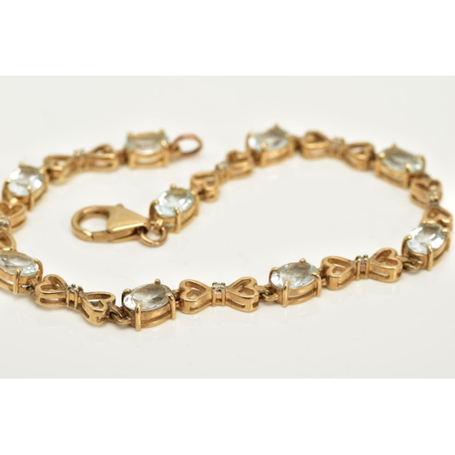 55 - A YELLOW METAL QUARTZ AND DIAMOND LINE BRACELET, designed with nine oval cut colourless quartz, inte... 